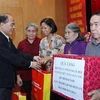 Chủ tịch Quốc hội Nguyễn Sinh Hùng tặng quà cho các gia đình chính sách tại buổi lễ. (Ảnh: Nhan Sáng/TTXVN)