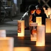 Các em nhỏ Nhật Bản đốt đèn hoa đăng trước các khu nhà tạm nhằm gửi đi thông điệp tái thiết Đông Bắc sau thảm họa. (Ảnh: Mainichi Shimbun)