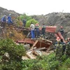Lực lượng quân đội, công an, công nhân mỏ than khẩn trương đào bới tìm kiếm người bị nạn vụ sạt lở bãi thải Mỏ than Phấn Mễ. (Ảnh: Thảo Nguyên/TTXVN)
