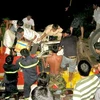 Lực lượng cứu hộ đưa các nạn nhân và hành lý ra khỏi xe ôtô bị nạn. (Nguồn: TTXVN)