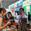 Khách hàng tại hội chợ tìm hiểu về càphê Việt Nam. (Ảnh: Xuân Vịnh/TTXVN)