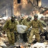 Lực lượng cứu hộ Nhật Bản vận chuyển thi thể nạn nhân thảm họa kép. (Nguồn: Reuters)
