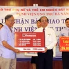 Đại diện Ngân hàng Nông nghiệp và phát triển Nông thôn (bên phải) trao tặng bảng tượng trưng số tiền, quà cho đại diện Bệnh viện Ung thư Đà Nẵng. (Ảnh: Trần Lê Lâm/Vietnam+)
