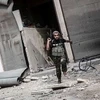 Một tay súng của quân nổi dậy cố hắng thoát khỏi một điểm giao tranh ở Aleppo, ngày 24/10. (Nguồn: AP)