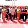 Tổng Bí thư, Chủ tịch nước Lào Chummaly Saynhasone và các vị đại biểu cắt băng khánh thành trường Trung học Xaysettha. (Ảnh: Hoàng Chương/Vietnam+)