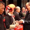 Phó Thủ tướng trao quà cho người có uy tín tiêu biểu tại hội nghị. (Ảnh: Xuân Tiến/Vietnam+) 