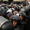 Lực lượng an ninh Ai Cập canh gác bên những người biểu tình ủng hộ Tổng thống Morsi ở bên ngoài trụ sở Tòa án Hiến pháp Tối cao Ai Cập, tháng 12/2012. (Nguồn: Xinhua)