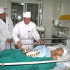 Các bác sỹ thăm bệnh nhân Vũ Văn Minh. (Ảnh: Mạnh Khánh/Vietnam+)