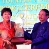 Ông Chaleun Warinthrasak, Thứ trưởng Bộ Thông tin, Văn hóa và Du lịch Lào trao biểu tượng đăng cai Diễn đàn Du lịch ASEAN cho đại diện Bộ Du lịch Malaysia. (Ảnh: Hoàng Chương/Vietnam+)