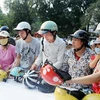 Người dân đến đổi mũ bảo hiểm mới của công ty B’color tại công viên Thống Nhất. (Ảnh: Quang Quyết/TTXVN)
