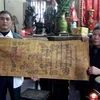 Ông Bùi Minh Quang (trái) trao sắc phong cho đền Bảo Lộc. (Ảnh: Nguyễn Trường/Vietnam+)