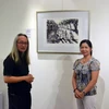 Họa sỹ Singapore, Choo Meng Foo (trái) giới thiệu với khách tham quan về tác phẩm của mình. (Ảnh: Chí Giáp/Vietnam+)