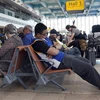 Hành khách mệt mỏi chờ đợi sau khi các chuyến bay bị hoãn. (Nguồn: AP)