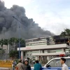 Hiện trường vụ cháy nhìn từ bên ngoài cổng nhà máy của công ty Pou Yuen Việt Nam. (Ảnh: Mạnh Linh/TTXVN)