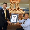 Nhân viên Tổ chức công nhận những Kỷ lục Thế giới Guines trao chứng nhận Mô hình Tháp Eiffel bằng diêm cao nhất thế giới cho anh Tufiq Daher. (Ảnh: AFP/TTXVN) 