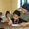 Chiến sĩ Đoàn 345 hướng dẫn học thêm cho các em học sinh tiểu học xã A Mú Sung, Bát Xát, Lào Cai. (Ảnh: Trọng Đức/TTXVN) 