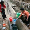 Người dân lấy nước tại một hố nước rất đục để dùng. (Ảnh: Xuân Trường/TTXVN) 
