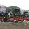 Những người biểu tình "áo đỏ" và đoàn tàu chở trang thiết bị, vũ khí quân sự tại tỉnh Khon Kaen. (Ảnh: Reuters)