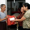 Đại diện của Quỹ “Vì nỗi đau da cam” của TTXVN trao quà cho các gia đình nạn nhân. (Ảnh: Huy Hùng/TTXVN)