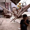 Một cậu bé bên trong ngôi nhà bị hư hại do trận động đất gây ra. (Nguồn: AFP)