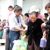 Ông Trần Chí Hùng (trái) tặng quà cho người dân vùng lũ lụt. (Ảnh: Đức Ánh/TTXVN)