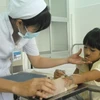 Bác sỹ chăm sóc cho trường hợp trẻ bị hở môi. (Ảnh: Thanh Vũ/TTXVN)