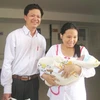 Anh Chiều và chị Thơm phấn khởi đưa cháu bé ra viện. (Ảnh: Vietnam+)
