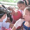 Bác sỹ kiểm tra sức khỏe về răng miệng cho trẻ em. (Ảnh: TTXVN)