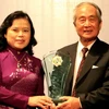 Đại diện Bộ Y tế trao giải thưởng cho Giáo sư Vũ Văn Đính.( Ảnh: TTXVN)