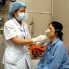 Bác sỹ điều trị cho bệnh nhân hen phế quản ở Bệnh viện Bạch Mai. (Ảnh: TTXVN)