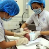 Nhân viên y tế chăm sóc cho trẻ sơ sinh mới trào đời. (Ảnh: Dương Ngọc/TTXVN)