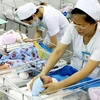 Nhân viên y tế chăm sóc cho trẻ sơ sinh. (Ảnh minh họa: Dương Ngọc/TTXVN)
