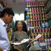 Cục trưởng Cục An toàn Thực phẩm kiểm tra các giấy tờ về việc thu hồi thức ăn công thức cho trẻ. (Ảnh: Thùy Giang/Vietnam+)
