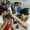 Bác sỹ khám cho bệnh nhân nhi đau mắt đỏ tại Hà Nội. (Ảnh: Dương Ngọc/TTXVN)