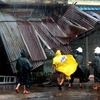Lực lượng cảnh sát cơ động giúp đỡ một hộ dân vừa bị bão làm sập mái hiên nhà tại Phú Yên. (Ảnh : Thế Lập-Ly Kha/TTXVN)