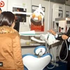 Gian trưng bày và giới thiệu máy khám chữa răng mới tại triển lãm Nha khoa Quốc tế lần thứ VII. (Ảnh: Hữu Oai/TTXVN)