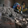 Đội cứu hộ tìm kiếm tại đống đổ nát sau vụ nổ bom. (Ảnh: Reuters)