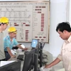 Chuyên gia nước ngoài và Việt Nam đang hiệu chỉnh thiết bị tại trung tâm điều hành của nhà máy thủy điện Bản Vẽ. (Ảnh: Nguyễn Văn Nhật/TTXVN)