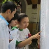 Học sinh xem điểm thi tốt nghiệp tại rường Marie Curie, quận 3, Thành phố Hồ Chí Minh. (Ảnh: Phương Vy/TTXVN)