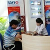 Nhân viên LVI đang bán bảo hiểm cho khách hàng. (Ảnh: Phạm Kiên/Vietnam+)