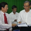 Ông Yang Kun Hsiang, Tổng giám đốc Vedan (phải) trao văn bản ký thỏa thuận cho luật sư Nguyễn Văn Hậu, đại diện nông dân Cần Giờ. (Ảnh: Hoàng Hải/TTXVN)