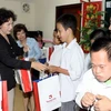 Bộ trưởng Nguyễn Thị Kim Ngân chia quà cho các cháu tại Làng Hữu Nghị. (Ảnh: Hữu Việt/TTXVN)