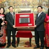 Bộ trưởng Bộ Nội vụ Trần Văn Tuấn trao tặng phiên bản khắc mộc bản Chiếu dời đô. (Ảnh: Nhật Anh/TTXVN)