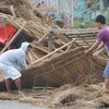 Người dân thu dọn ngôi nhà bị tàn phá tại Ilagan, miền bắc Philippines ngày 20/10, sau khi bão Megi tràn qua. (Nguồn: AFP/TTXVN)