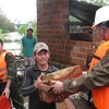 Trao hàng cứu trợ cho một gia đình bị sập nhà tại Phù Cát. (Ảnh: Viết Ý/TTXVN)