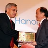 Đại diện Tổ chức Pháp ngữ trao giải thưởng cho ông Huỳnh Hữu Tuệ. (Ảnh: Nguyễn Dân/TTXVN)