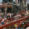 Lực lượng cứu trợ tìm kiếm người sống sót sau động đất và sóng thần tại thị trấn Minamisanriku ngày 15/3. (Nguồn: AFP/TTXVN)