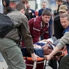 Chuyển người bị thương trong vụ nổ ngày 11/4. (Nguồn: AFP/TTXVN)