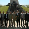 Đại sứ Đỗ Hòa Bình chụp ảnh cùng một số thành viên trong đoàn trước Đài tưởng niệm. (Ảnh: Văn Long-Thanh Hải/Vietnam+)