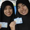 Phụ nữ người Hồi giáo Thái Lan giới thiệu thẻ căn cước của họ trước khi bỏ phiếu. (Nguồn: AFP/TTXVN)